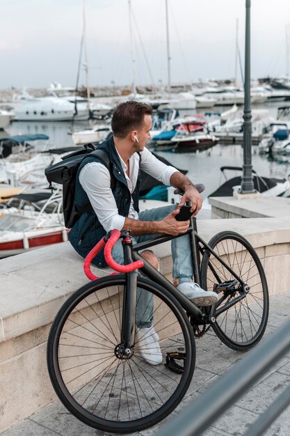 Hombre sentado y mirando a otro lado junto a su bicicleta