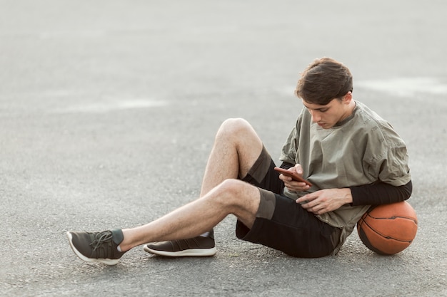 Hombre sentado con una pelota de baloncesto