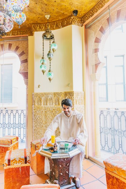 Hombre sentado en restaurante arabe