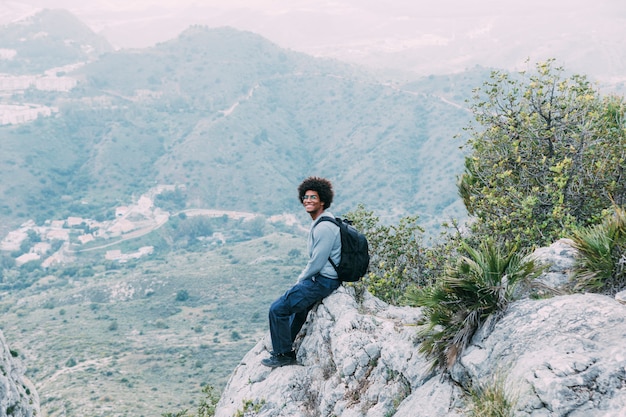 Hombre sentado en roca en la naturaleza