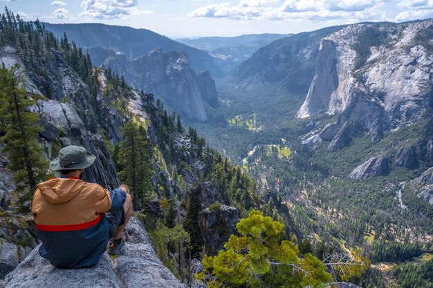 Hombre sentado sobre una roca en el Parque Nacional de Yosemite, Sentinel Dome Yosemite, EE.