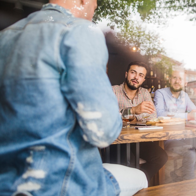 Foto gratuita hombre sentado con sus amigos en el restaurante