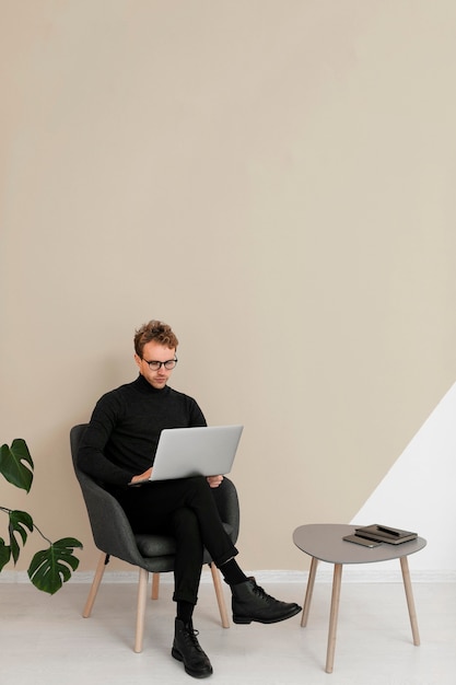 Foto gratuita hombre sentado y trabajando en una computadora portátil