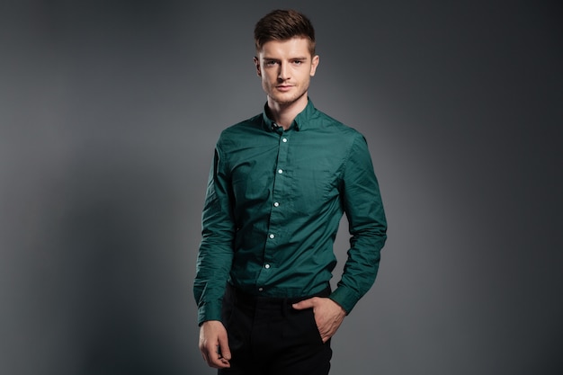 Hombre serio guapo vestido con camisa posando