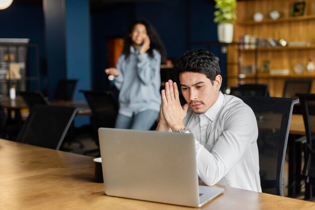 Hombre serio en el trabajo trabajando en la computadora portátil en el escritorio