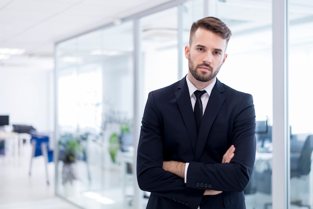 Hombre serio en traje con los brazos juntos