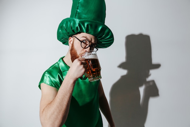 Foto gratuita hombre serio en traje de patriotas de st. bebiendo cerveza