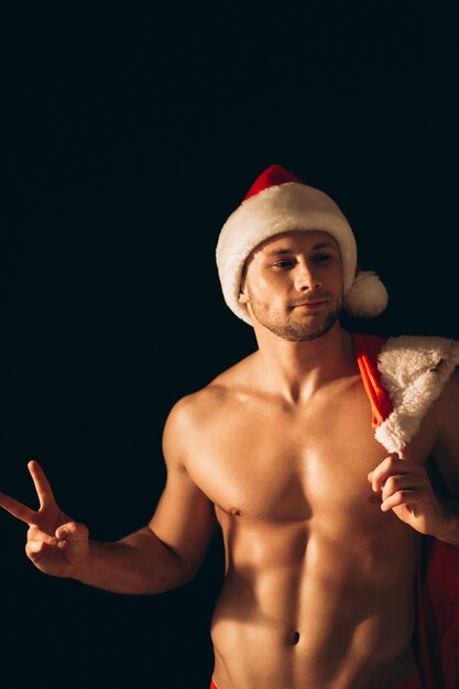 Hombre sexy de santa desnudo sobre fondo negro