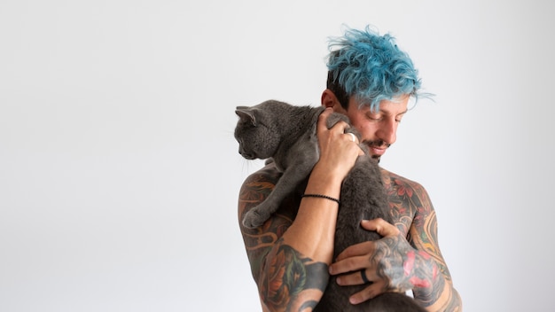 Foto gratuita hombre siendo cariñoso con gato tiro medio