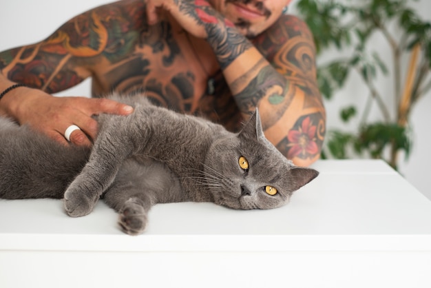 Foto gratuita hombre siendo cariñoso con lindo gato vista frontal