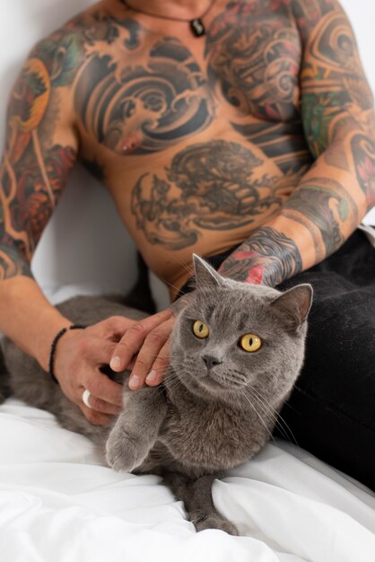 Hombre siendo cariñoso con lindo gato vista frontal