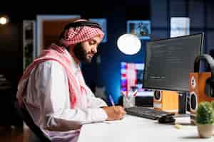 Foto gratuita el hombre se sienta frente a una computadora que muestra códigos