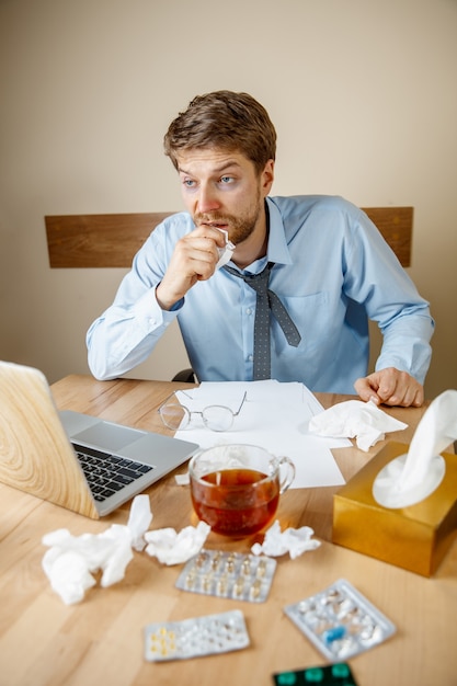 El hombre se siente enfermo y cansado, trabajando en casa