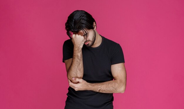 El hombre siente un fuerte dolor de cabeza y parece cansado