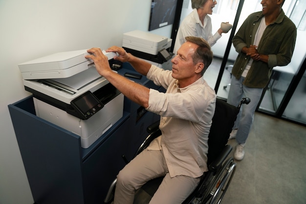 Foto gratuita hombre en silla de ruedas que tiene un trabajo de oficina