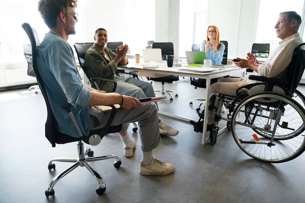 Foto gratuita hombre en silla de ruedas que tiene un trabajo de oficina