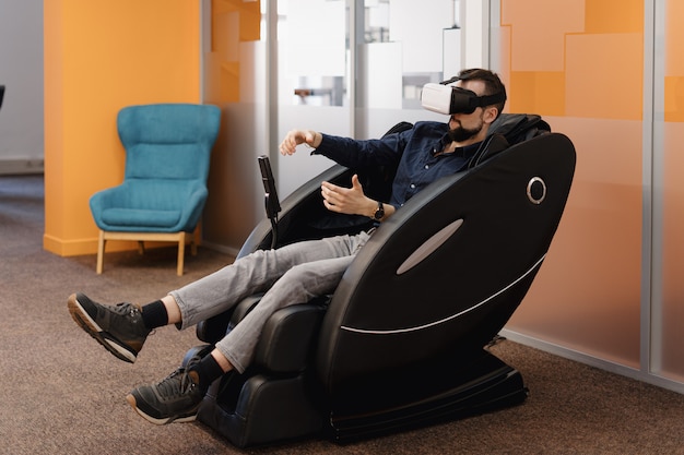 Un hombre en un sillón de masaje con tecnología VR