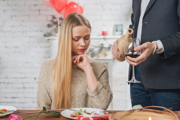 Hombre sirviendo vino para mujer en cita