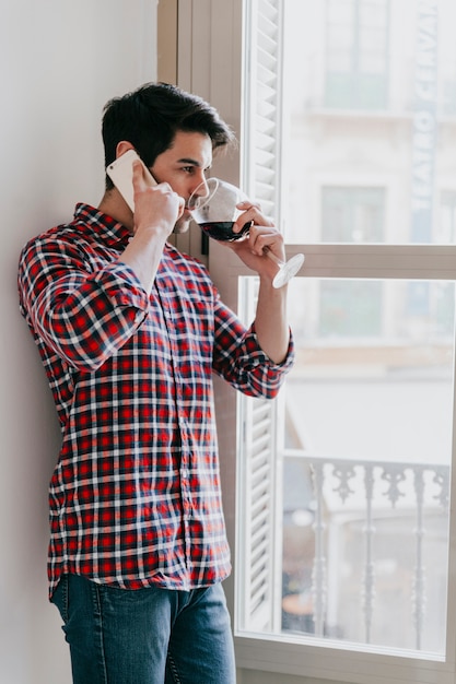 Hombre con smartphone bebiendo vino