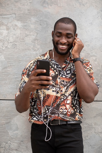 Foto gratuita hombre con smartphone moderno con auriculares