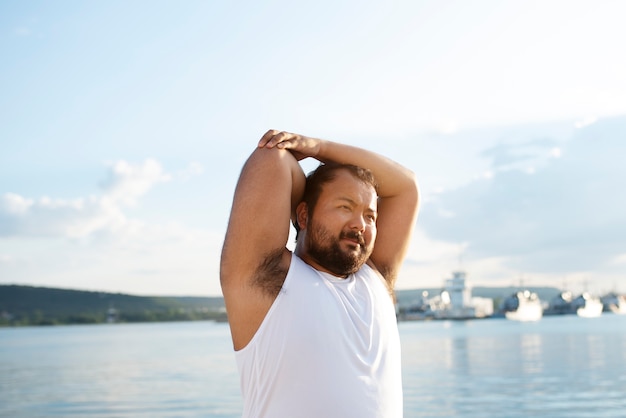 Foto gratuita hombre con sobrepeso haciendo ejercicio al aire libre