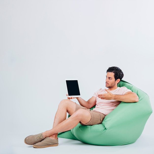 Hombre en sofá mostrando tablet