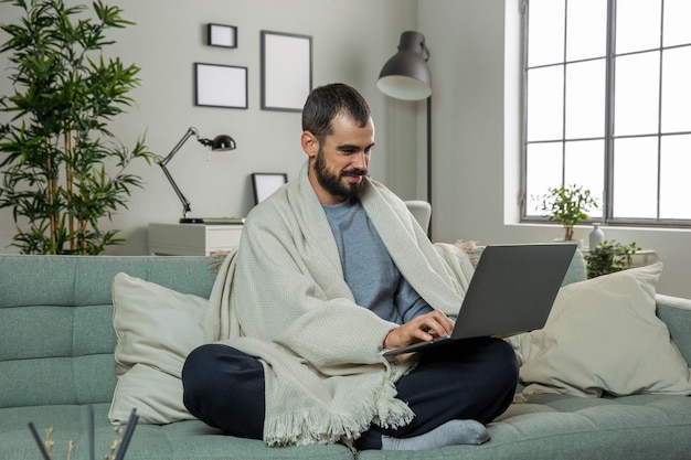 Foto gratuita hombre en el sofá trabajando en equipo portátil