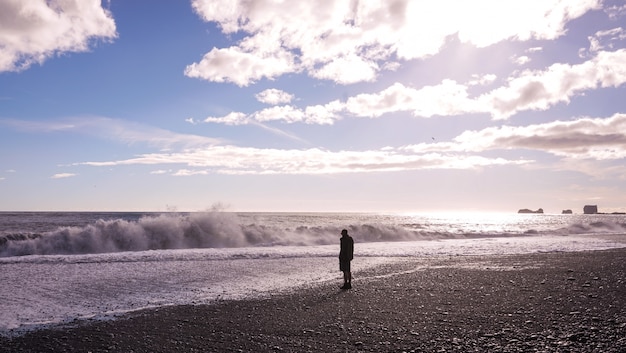 Un hombre solitario parado en la playa.