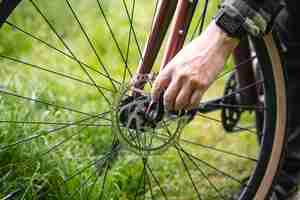 Foto gratuita un hombre soluciona un problema con una rueda de bicicleta generativa ai