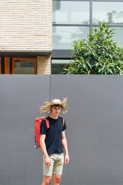 Hombre con sombrero de paja en la cabeza con mochila de equipaje