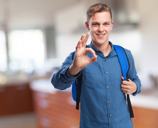 Hombre son una mochila haciendo ok con la mano