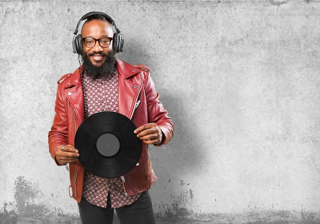 Hombre sonriendo con auriculares y un disco de vinilo