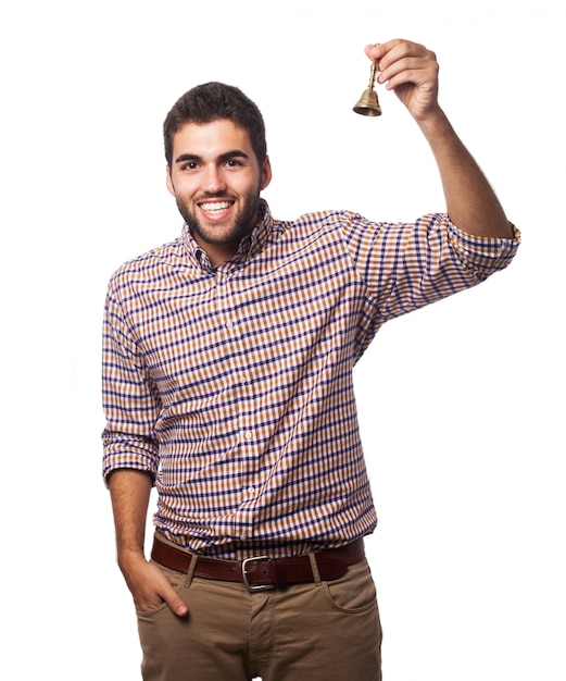 Hombre sonriendo con una campana de mano