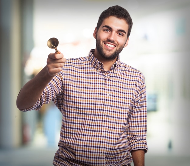 Hombre sonriendo con una campana pequeña