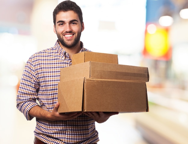 Hombre sonriendo cargando con cajas