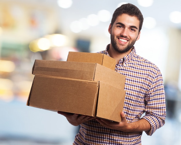 Foto gratuita hombre sonriendo cargando cajas