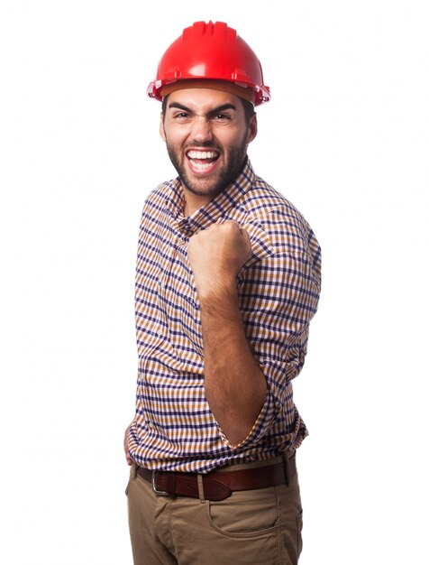 Hombre sonriendo con un casco rojo y un puño levantado