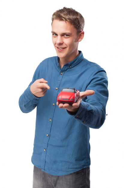 Hombre sonriendo con un coche de juguete