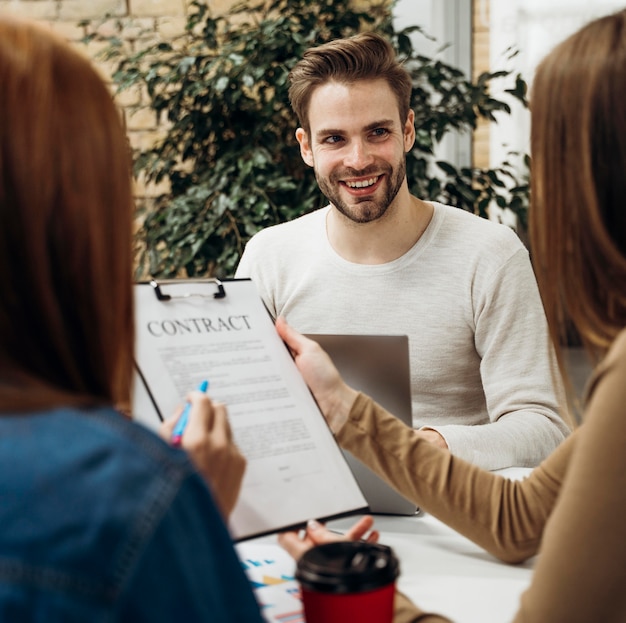 Foto gratuita hombre sonriendo a compañeros de trabajo en una reunión