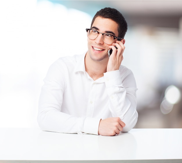 Hombre sonriendo hablando por un teléfono inteligente