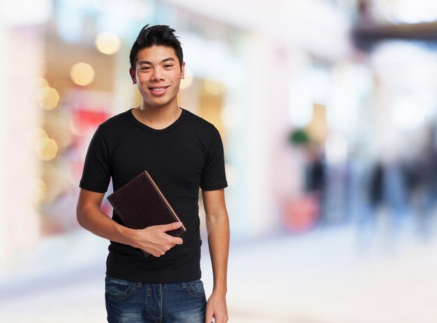 Hombre sonriendo con un libro cerrado