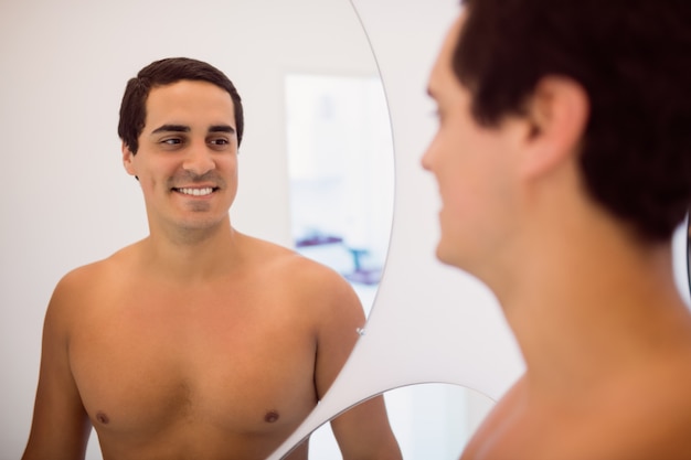 Hombre sonriendo mientras está parado frente al espejo