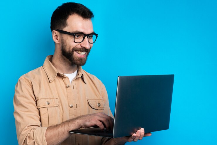 Foto gratuito hombre sonriendo mientras mira portátil