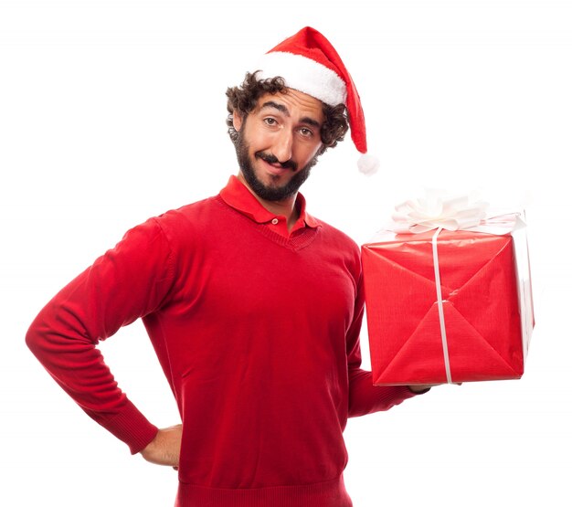 Hombre sonriendo con el sombrero de papa noel y un regalo