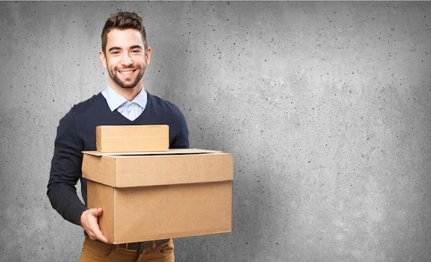 Hombre sonriendo sujetando cajas de cartón