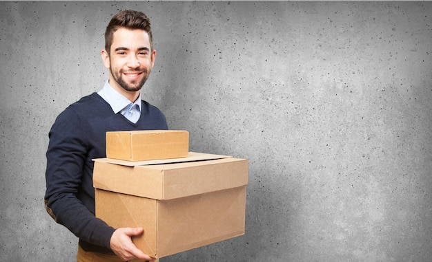 Hombre sonriendo sujetando cajas de cartón