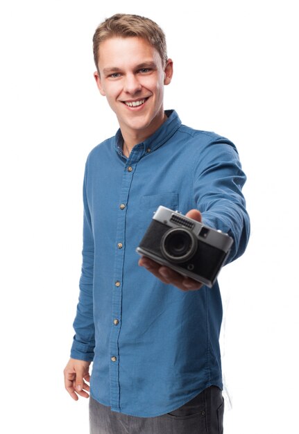 Hombre sonriendo sujetando una cámara antigua