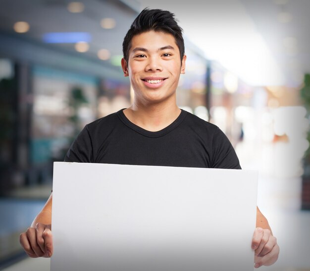 Foto gratuita hombre sonriendo sujetando un cartel blanco