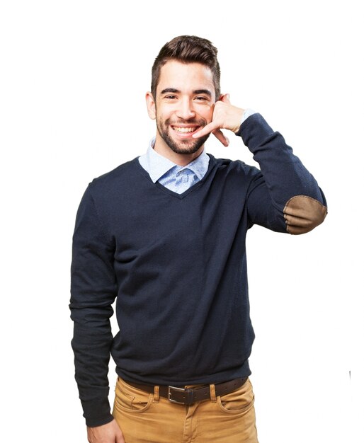 Hombre sonriendo con un teléfono echo con su mano