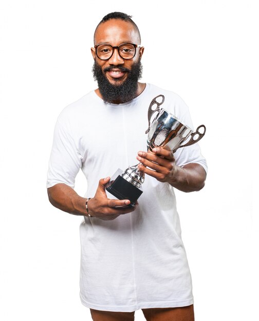 Hombre sonriendo con un trofeo plateado